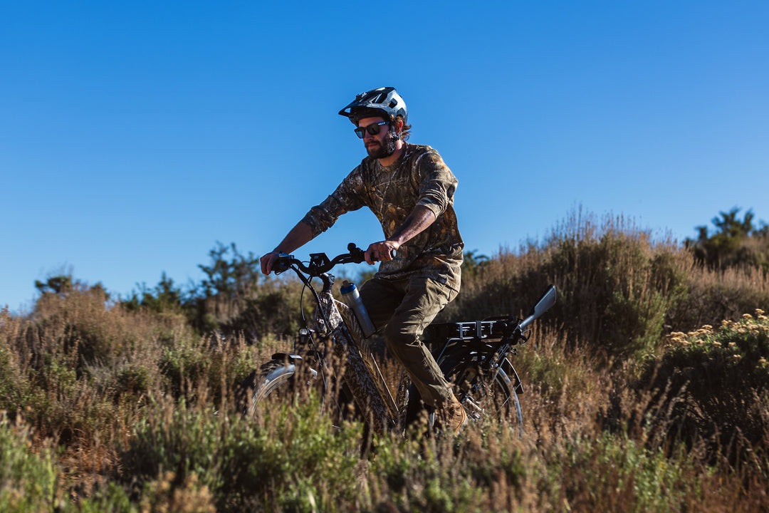 male riding Dirwin Pioneer Plus Fat Tire Electric Bike offroad through thick bushes