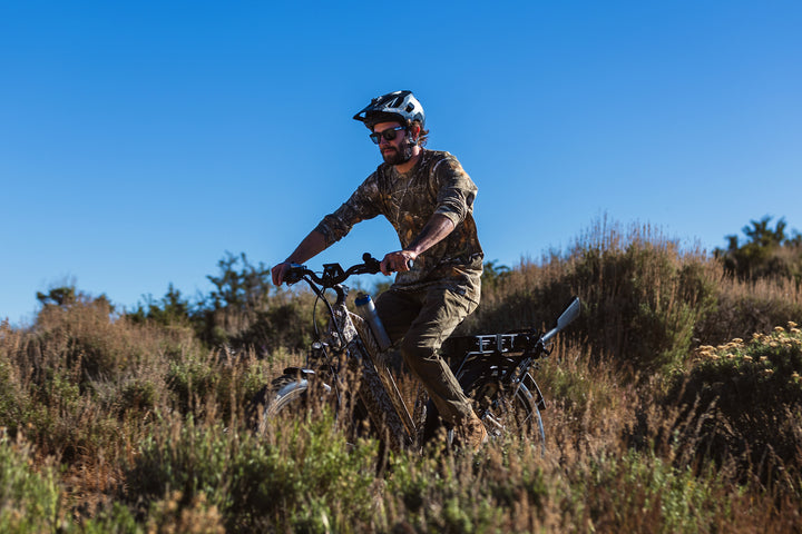 male riding Dirwin Pioneer Plus Fat Tire Electric Bike offroad through thick bushes