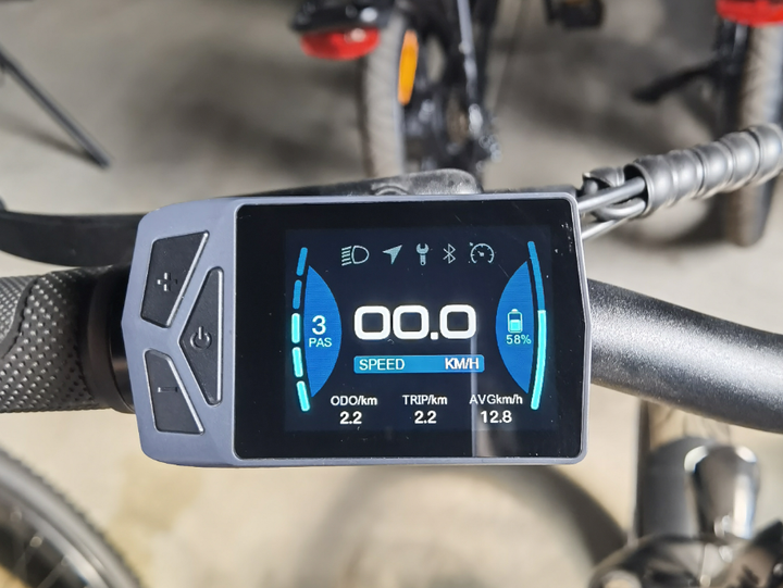 Digital display on a bicycle handlebar with various metrics.