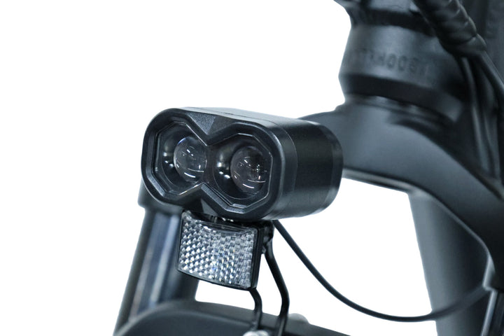 Close-up of the dual-lens LED headlight and front reflector on the Dirwin Pioneer electric hunting bike